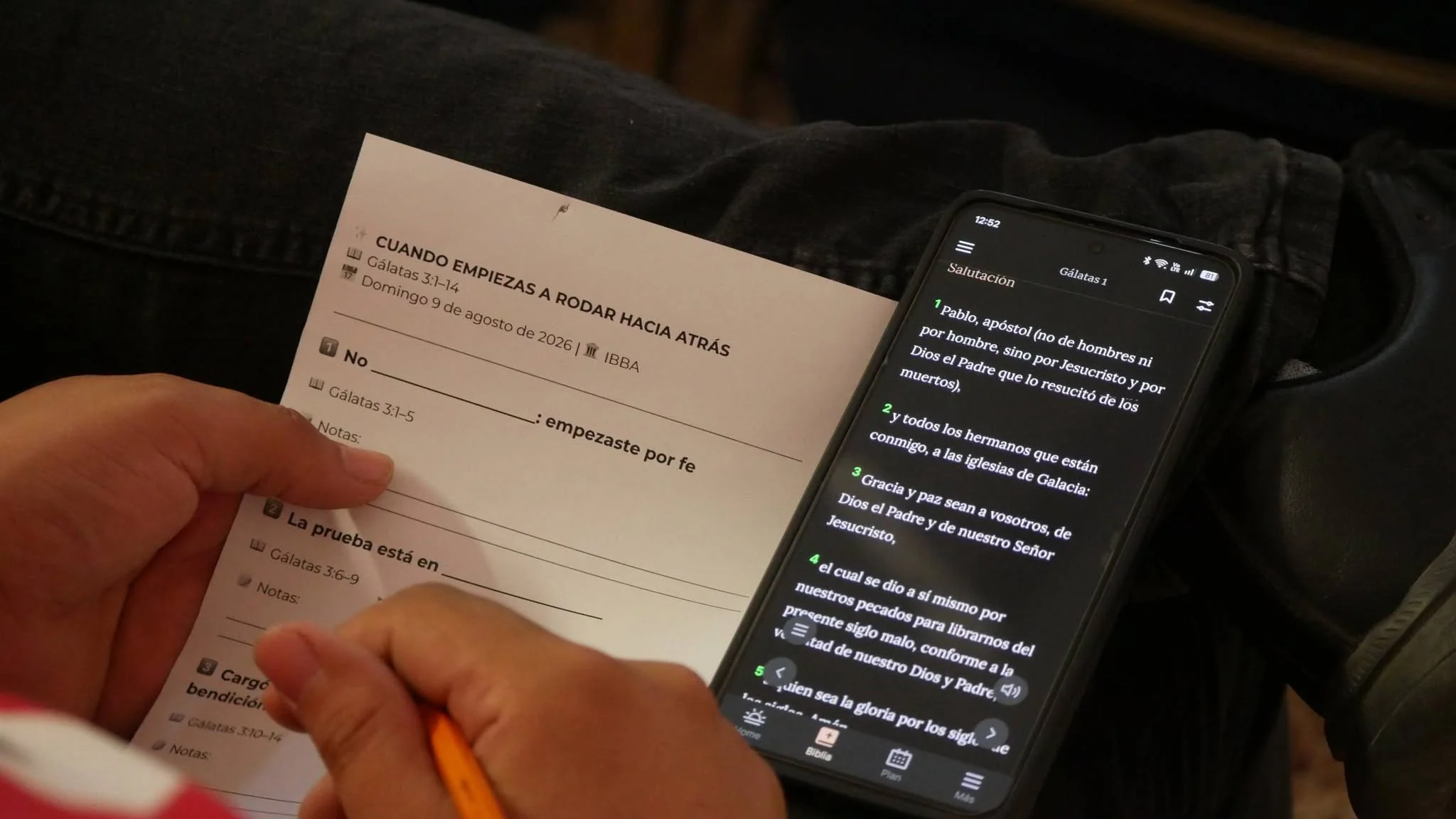 Una tarjeta de notas del sermón junto a un teléfono con la Biblia abierta