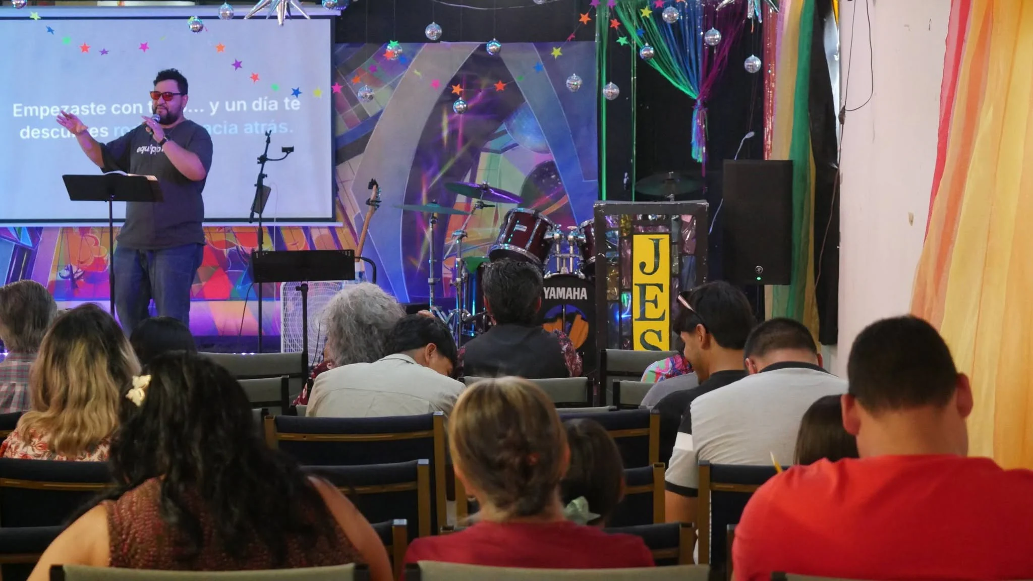 La congregación de espaldas, de frente al escenario durante el servicio