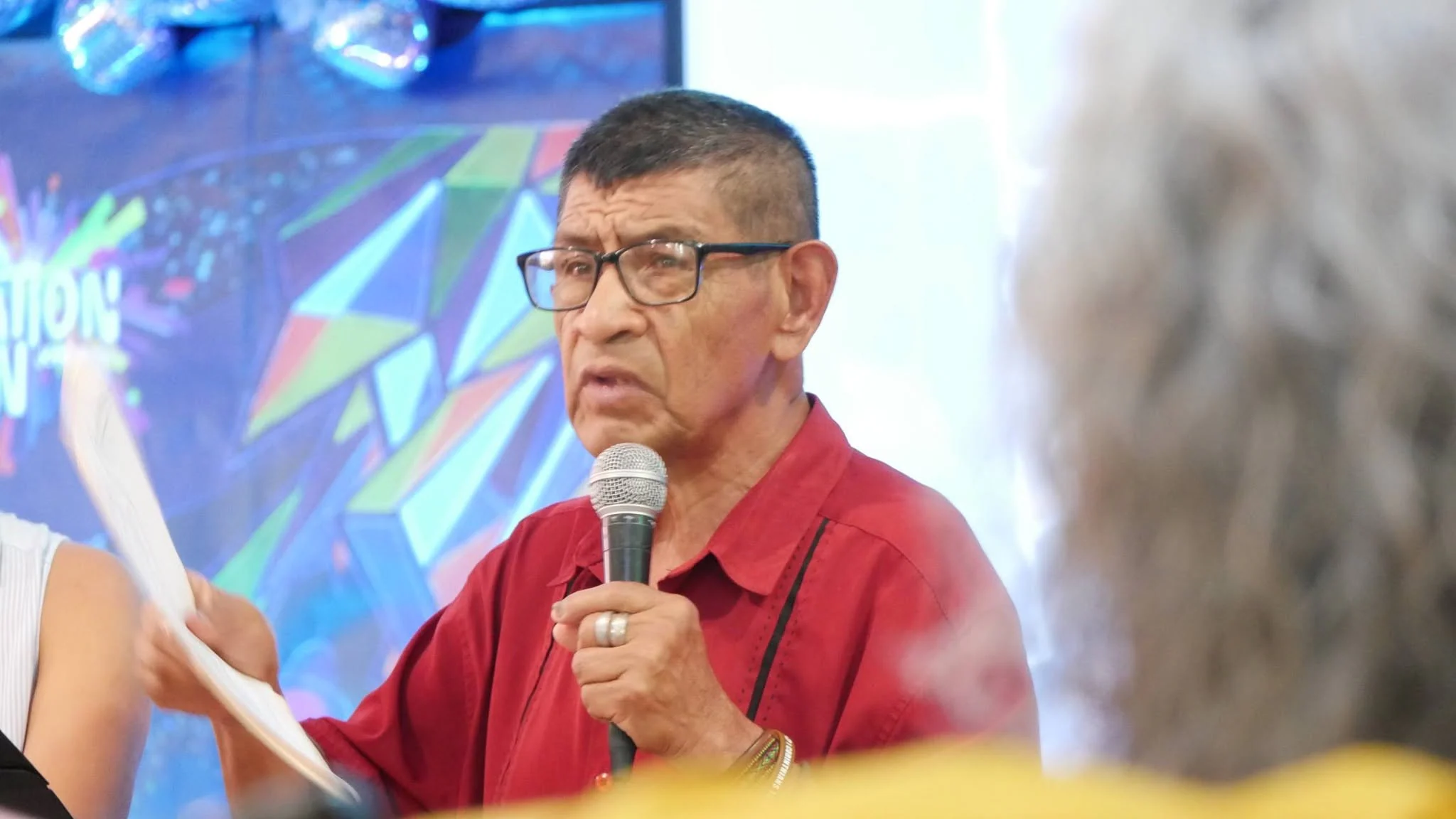 Un hermano de la congregación hablando con el micrófono en la mano